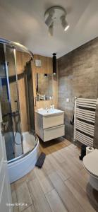 a bathroom with a tub and a sink and a toilet at Łebska Zagroda in Łeba
