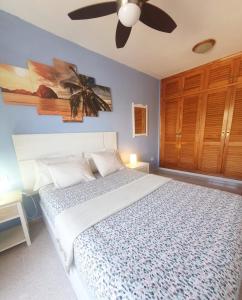 Un dormitorio con una cama con ventilador de techo. en Views of El Medano beach, two, en El Médano
