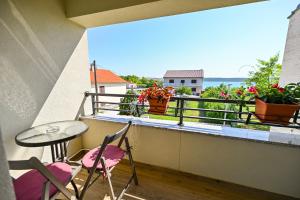 a balcony with a table and chairs and flowers at Apartman Kate in Ljubač