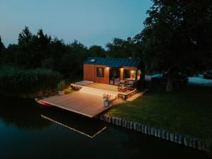 a tiny house on a dock in the water at Feelmore Tiny House Szarvas in Szarvas