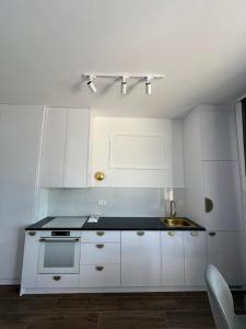 a kitchen with white cabinets and a sink at Azurno Pristaniste 3 in Njivice