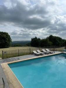 a swimming pool with lounge chairs and a fence at Gîte de Brohimont Vakantiehuis - Exceptional Cottage location - Uitzonderlijke locatie in Houyet