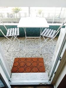 a table and chairs and a table and a rug at Manzoni house next como lake station in Como