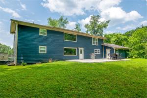 une maison bleue avec une pelouse devant elle dans l'établissement Creekfront Lodge By Avada Properties, à Pigeon Forge
