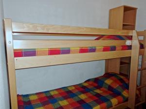 圣索林达尔沃Charmant appartement 4 personnes Centre station的一张木制双层床,上面有色彩缤纷的毯子