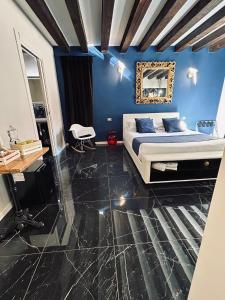 ein Schlafzimmer mit einem Bett und einer blauen Wand in der Unterkunft Dimora Fattorini in Chioggia + 33 Fotos