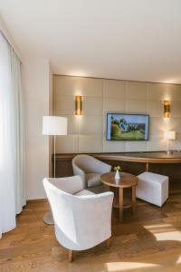 a living room with white chairs and a table at Hotel & Spa Larimar in Stegersbach