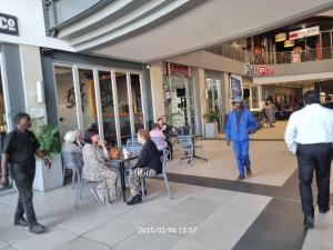 a group of people sitting at a table in a shopping mall at Genesis on Fairmount in Johannesburg