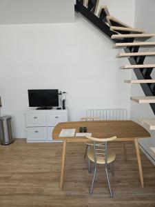 a dining room with a table and a staircase at Petite maison, Oyonnax centre in Oyonnax