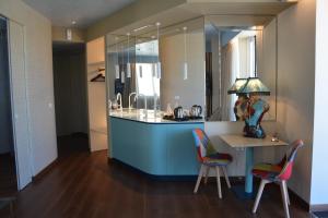 a kitchen with a island with a table and two chairs at Alba Suites in Vlorë +77 photos