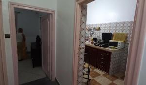 une personne debout dans une cuisine avec un four micro-ondes dans l'établissement Traditional Cosy Apartment Downtown Guéliz, à Marrakech