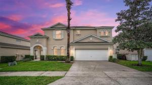 a house with a palm tree and a garage at 509 Relax Play at This 6BR Pool Home in Haines City