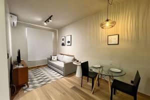 una sala de estar con un sofá y una mesa en Confortável Flat no Centro, en Londrina