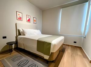 Un dormitorio con una gran cama blanca con ventana. en Confortável Flat no Centro, en Londrina 27 fotos más