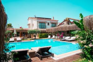 a swimming pool with lounge chairs and a house at Albeon Luxury Hotel - Alacatı in Alaçatı