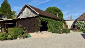 a barn with ivy growing on the side of it at La Ferme du Croît - Proche Lacs & Observatoires in Villehardouin