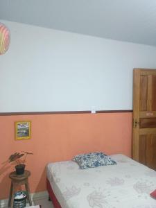 a bedroom with a bed with an orange and white wall at Casa na floresta cósmica in Ananindeua