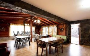 a dining room with tables and chairs and a stone wall at Vila Savy in Baile Felix