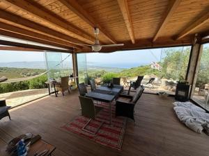 a dining room with a table and chairs on a deck at Casa Golfo Asinara,Ocean view, private pool, fully air-conditioned, secluded location in Trinità dʼAgultu