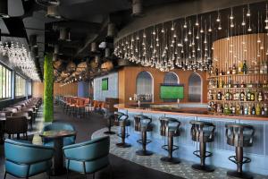 um bar com cadeiras, mesas e lustres em Holiday Inn Express Dubai Internet City by IHG no Dubai