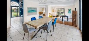 ein Esszimmer mit einem Holztisch und Stühlen in der Unterkunft Villa Markaly in Vigneux-de-Bretagne