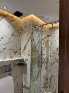 a bathroom with a shower with marble walls at Joli Studio with Seaview 16 in Casablanca