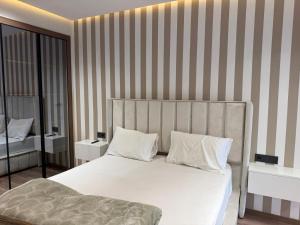 a bedroom with a large white bed with striped walls at Joli Studio with Seaview 16 in Casablanca
