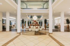 a lobby with columns and a christmas tree at IFA Graal-Müritz Hotel & Spa in Graal-Müritz +141 photos