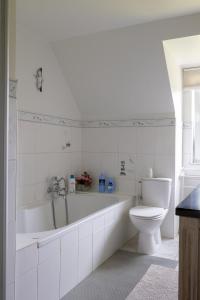 a white bathroom with a tub and a toilet at Villa De Ruiter in Waasmunster +18 photos