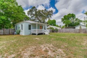 a blue house in a yard with a fence at Sunset on the Bayou in Sanders Beach