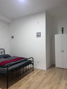 a bedroom with a bed and a white wall at ROYAL RACiNG SUiTE TOP 2 in Judenburg