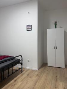 a bedroom with a bed and a white cabinet at ROYAL RACiNG SUiTE TOP 2 in Judenburg