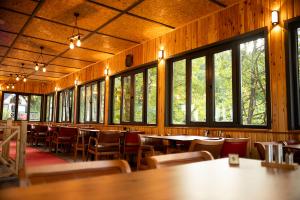 una sala da pranzo con tavoli, sedie e finestre di Alnada Resort a Düzköy