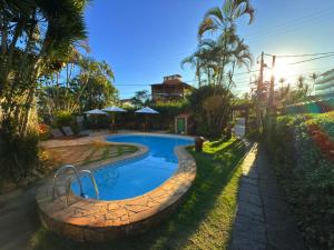 a swimming pool in the yard of a house at Pousada Sonho Verde in Rio das Ostras +92 photos