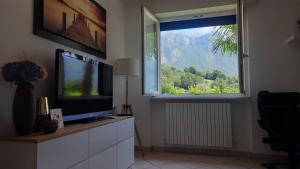 a living room with a tv and a window at Villa Sara - Lake view, Garden & Private Parking in Lecco