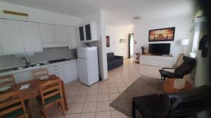 a kitchen and living room with a table and a refrigerator at Villa Sara - Lake view, Garden & Private Parking in Lecco