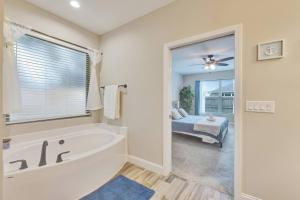 a bathroom with a tub and a bed and a window at SeaBreeze On David in Shalimar