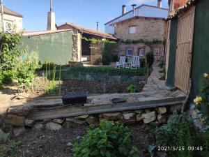 a garden with two chairs and a house at El Zoela in Ferreras de Arriba