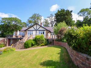 a house with a large lawn in front of it at The Old Barn in Ruthin