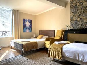 a bedroom with two beds and a couch at Autour d'une Toile in Rouvenac