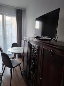 a television on top of a wooden cabinet with a table at Bagry Rooms3 LoveKrakow in Kraków