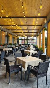 a dining room with tables and chairs and lights at Condor Resort in Dulceşti