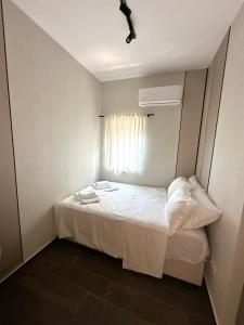 a small bedroom with a bed with a window at Azurno Pristaniste 1 in Njivice