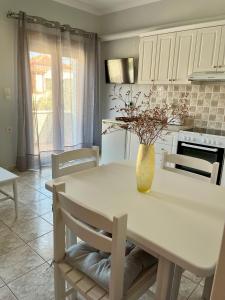a white kitchen with a table with a vase on it at Agapi's Nest in Petra