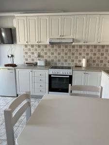 a kitchen with white cabinets and a table with chairs at Agapi's Nest in Petra