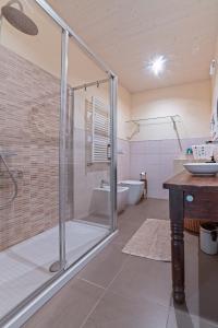 a bathroom with a glass shower and a sink at The Casalo in Finale Ligure