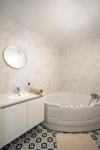 une salle de bain blanche avec une baignoire et un lavabo dans l'établissement 10min de Disney Duplex 2ch avec Parking & Balcon, à Bailly-Romainvilliers