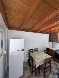 a kitchen with a table and a white refrigerator at Denaj House in Himare