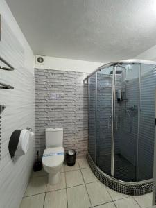 a bathroom with a toilet and a glass shower at Royal Suite in Odesa