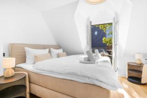 une chambre avec un grand lit blanc avec une fenêtre dans l'établissement Sky & Sand, à Westerland